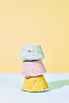 Heap of colorful handmade natural bath bombs staked on light background in studio