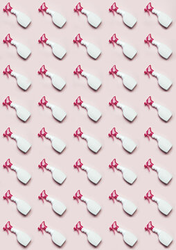 Top view of plastic bottles with window cleaner placed in even rows on pink background
