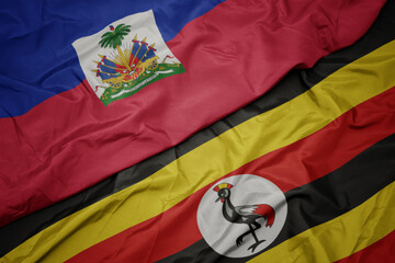 waving colorful flag of uganda and national flag of haiti.