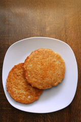 Potato pancakes on a white plate, fatty and unhealthy food, high-calorie and delicious dish.