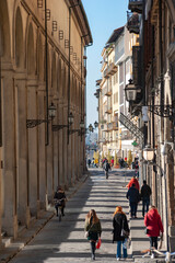 Florence, Italy - 2020, January 18: People walking in the streets, along the arches of the Corridoio Vasariano, in a sunny day..