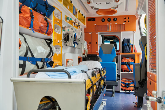 Interior of contemporary ambulance car equipped with various professional instruments and medical stretcher