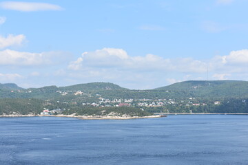 land and mounatins across the blue ocean on a summer day