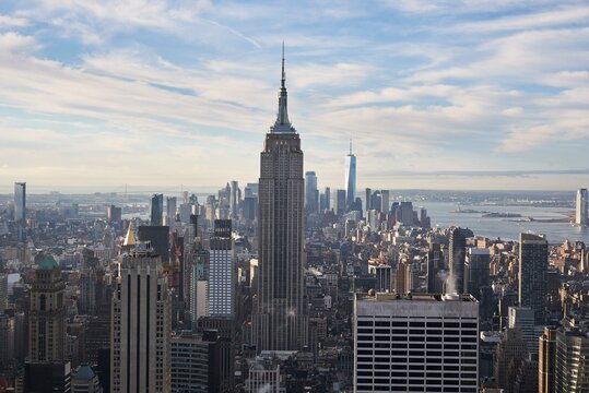 Magnificent view of Manhattan with tall glass skyscrapers on background of blue cloudy sky in New York