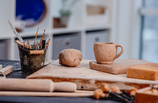Pottery tools, cup and clay at workshop