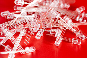 Fototapeta premium Pile of white LED diode on red background. Electronic components and spare part.