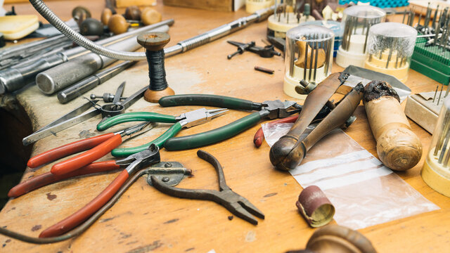 Set of various professional instruments and tools  placed on shabby wooden table in jeweler workshop