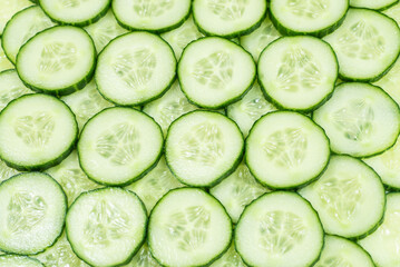 Fresh green slices of cucumber as background.
