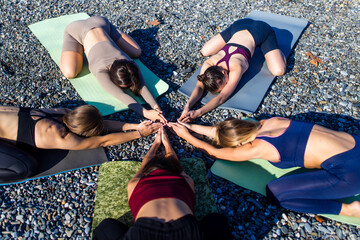 group of five women practicing yoga assans in morning beach . only girls session