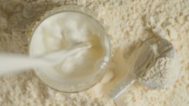 Protein powder and measuring scoop over the jar.