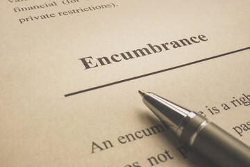 Obraz premium Encumbrance word on the page with pen.