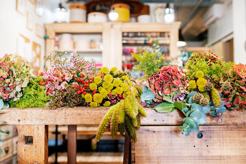Wooden table at floristry workshop full of flowers for arrangements