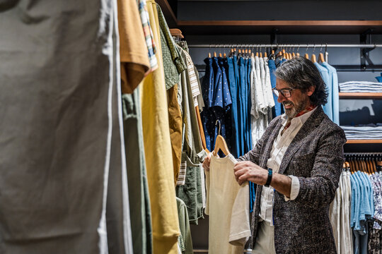 Side view of man choosing clothes in a clothing store
