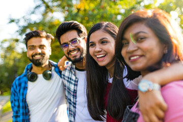 four people having fun outdoors, focus on beautiful indian woman
