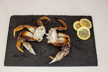 Raw, cleaned, uncooked Dungeness crab legs sit on a platter in the kitchen ready to be cooked for dinner