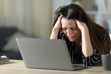 Sad woman complaining reading laptop content