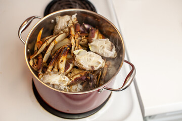 Dungeness crab legs are being put into a large, boiling pot of water to be steamed and cooked eaten for dinner