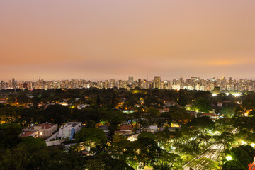 Fototapeta premium Aerial view of São Paulo city skyline at night, park, streets, houses, trees and buildings in the background at dusk. Concept of urban, city, architecture, cityscape, metropolis, business, tourism.