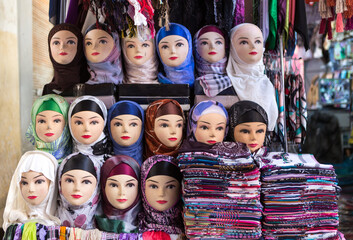 Mannequin of arab women wearing colorful fabric hijab on head in market in Morocco. Concept of travel, religion, islam, clothing, fashion, arab art, tourism, shop, sale, tradition and devotion.
