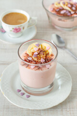 Homemade healthy breakfast on Valentine's Day: pink  pudding with banana, chocolate and heart shape candy sprinkles