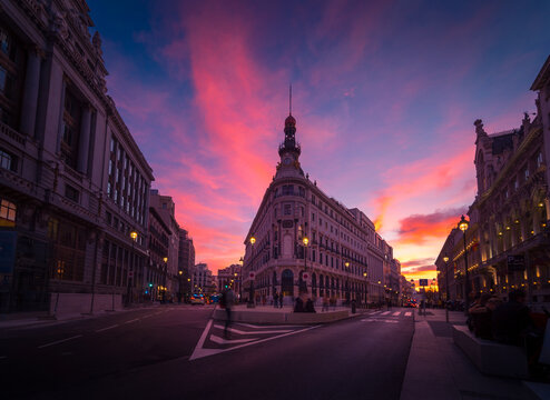 Low angle of Metropolis Building on background of colorful sunset sky in Madrid in long exposure