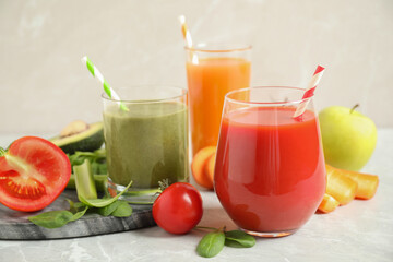 Fototapeta na wymiar Delicious vegetable juices and fresh ingredients on light grey table