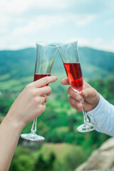 Glasses with red champagne drink in bride and groom hands. Happy newlyweds drinking. Loving couple created new family.