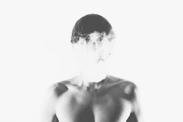 Black and white of unrecognizable young shirtless guy smoking cigarette and looking at camera against light background