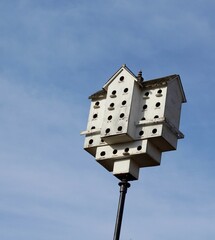 The large white birdhouse with the sky in the background.