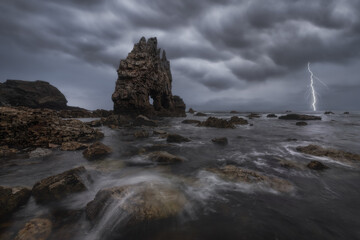 Dramatic view of bright lightning in gloomy cloudy sky flashing above sea during thunderstorms in highland area
