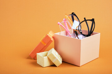 several different glasses in a beige gift box, small gift boxes on a brown background copy space