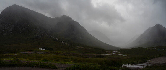Breathtaking panorama of landscape with rocky mountains against gray cloudy sky in Scotland