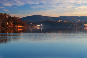 Brno Dam Czech Republic Europe. Water surface and dam. In the background is the housing estate Bystrc and Kohoutovice. The sky is blue with white clouds