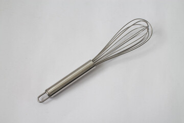 A silver whisk on white background.