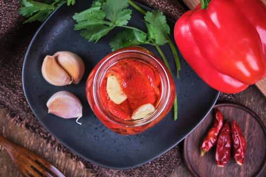 Vegan baked red peppers with garlic in crystal jar.