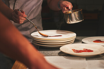 Chefs preparing beautiful dishes in French restaurant's kitchen