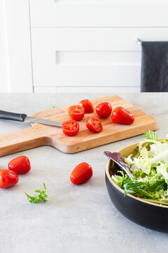 Salad green leaves in bowl placed in table with fresh tomatoes