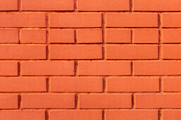 This photo shows empty background with brick, uneven texture wall painted red color for copy space.