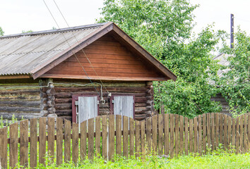 One-story wooden house in the countryside..Small old brown village building..