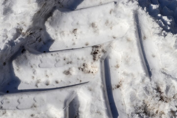 Tire Tracks on snow covered streets in a close up view.