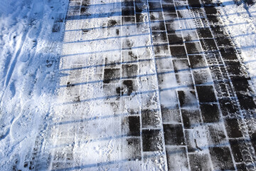 Tire Tracks on snow covered streets in a close up view.