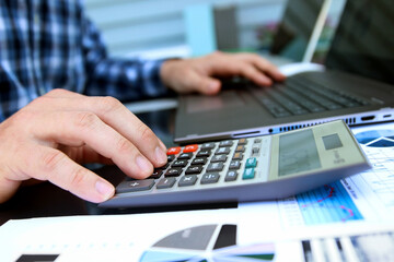 Businessman / accountant is doing calculations. Tax season. - obrazy, fototapety, plakaty