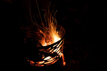 People around pit fire with flames