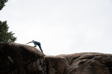 A climber reaching the top of a rock