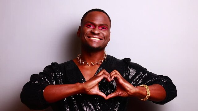 crossdress mixed race drag queen in glister dress feeling pride and confidence in make up in studio white background