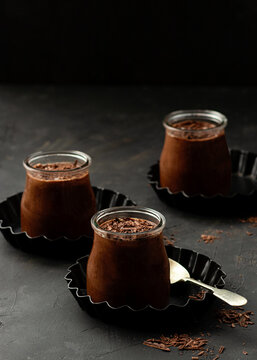 From above tasty chocolate mousse in glass jar arranged on table with chocolate powder dust