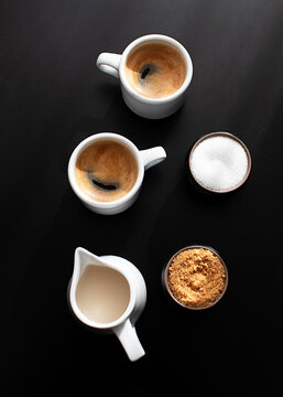 Cups of coffee served on a tray on dark background