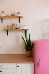 Kitchen shelves, wooden surface and pink fridge on white background. White kitchen interior counter...