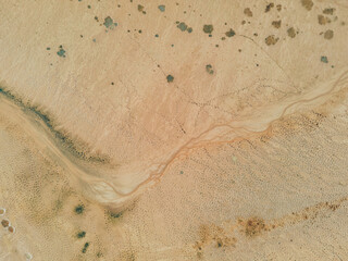 Top down view: small stream of water at the bottom of a dry lake. The unearthly landscape of the...