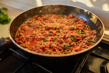 Spaghetti bolognese sauce being fried on a pan